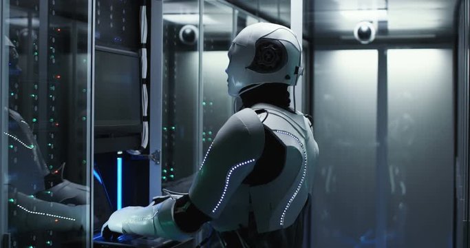 White android robot using computer and checking software of server equipment in room of modern data center