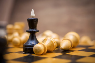 Chess leadership concept with gold and black chess, queen surrounded by pawns