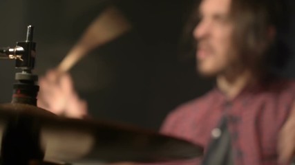 Long-haired drummers play drum kit in a dark room on a black background. Rock musician. Static plan. Wide angle