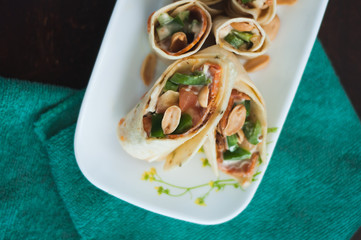 Fototapeta na wymiar Sushi-Style Wraps with chicken pepperoni, vegetables and nuts. Healthy snacks.