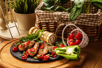 Roasted pork meat with pepper at decorated wooden table background.