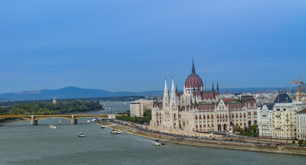 Fototapeta na wymiar Panorama of the Danube river. View of Budapest. Old buildings of the Hungarian Parliament and medieval temples and buildings.
