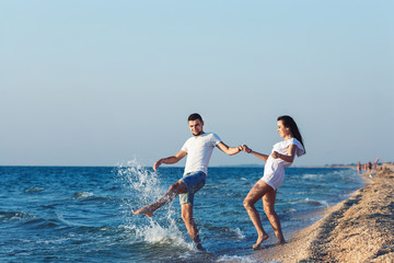 Obraz premium boy and girl fun splashing on the sea.