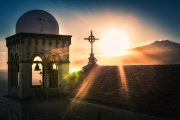 Volcano etna erupting from castelmola church and cross dramatic sunset