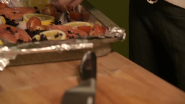 Closeup of girl's hand in home kitchen sprinkle chopped regen dish on a tray. Healthy home cooking