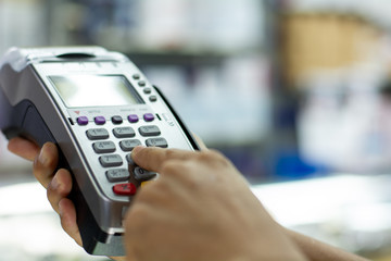 Paying by credit card with   paying with contactless credit card with a credit card reader machine.