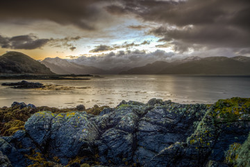 Beautiful Beach Sunset Seascape on The Isle Of Skye with Seaweed covered rocks 