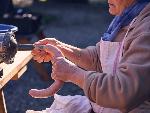Crop woman making meat sausage