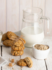 Oatmeal cookies with milk on tray on rustic wooden table