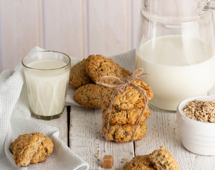 Oatmeal cookies with milk on tray on rustic wooden table