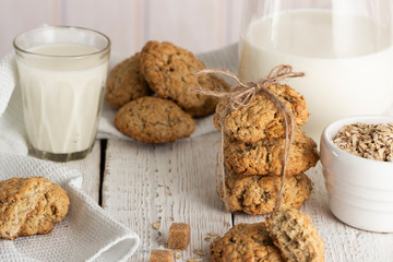Oatmeal cookies with milk on tray on rustic wooden table