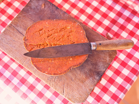 Knife on cut natural sausage