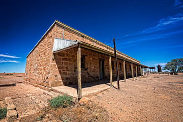 Australia – Outback desert with an old abandoned vintage railway station near the old Ghan under blue sky