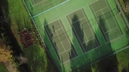 Players Play Tennis On A Green Court. Drone Aerial Top View. - Powered by Adobe