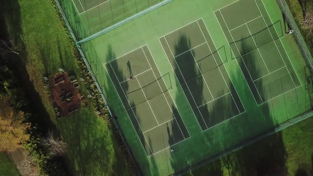 Players Play Tennis On A Green Court. Drone Aerial Top View. - Powered by Adobe
