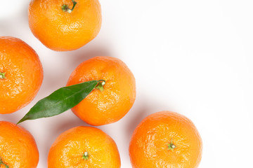 Ripe tangerines on a white background and one tangerine with green leaves in center