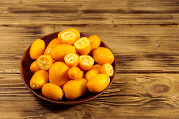 Fresh kumquat fruits on wooden table