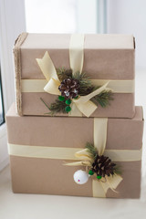 Gift box with ribbons decorations in the form of cones and branches of a Christmas tree close-up