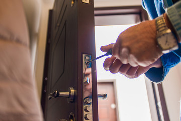 Obraz premium Workman standing near the door and fixing it