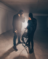 Masked men standing in a dark garage