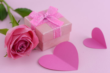 Pink rose and a gift box with hearts, valentine day background
