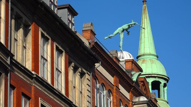 Sculpture of a naked man on the roof of the house. Copenhagen. Denmark. 4K.