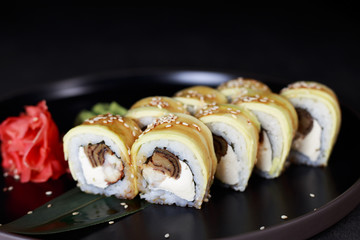 Restaurant menu, food background, traditional Japanese cuisine. Tasty appetizing uramaki sushi rolls with tamago omelet and eel fillings, close up