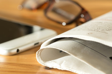 Eine Zeitung, Lesebrille und ein Smartphone