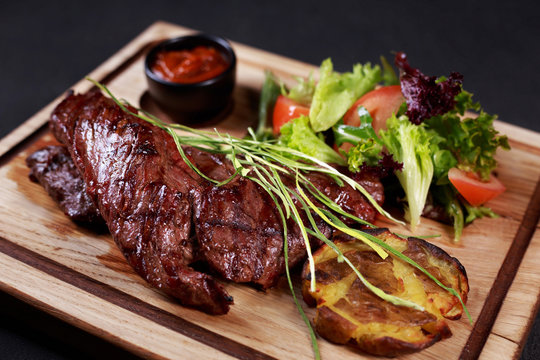 Grill And Barbeque, Meat Restaurant Menu, Skirt Steak, Beefsteak Served With Vegetable Salad And Potatoes On Board, Traditional American Cuisine