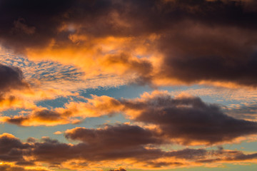 Nice sunset orange cumulus clouds on blue sky