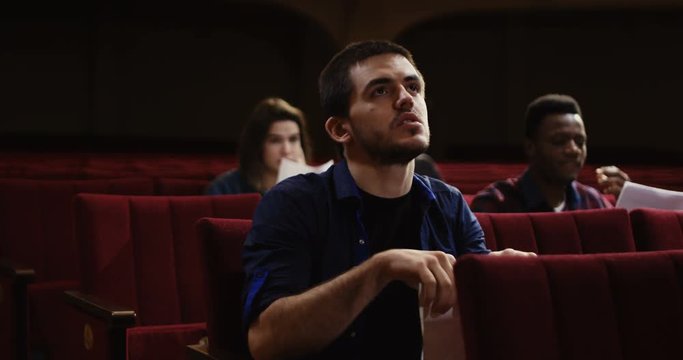 Medium shot of an actor rehearsing singing in the theater