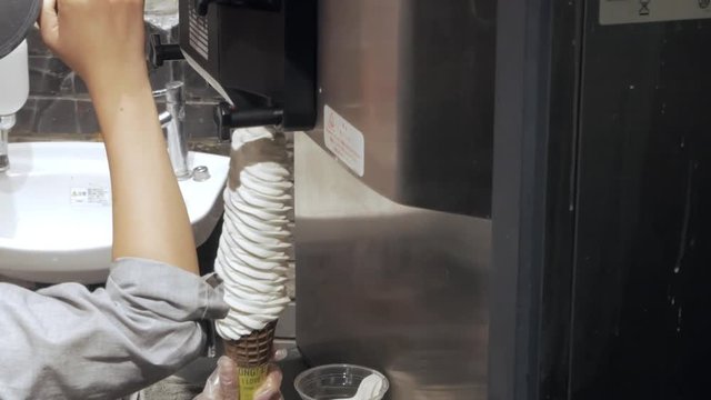 Soft-serve ice cream while serving in the waffle cone in giant portion