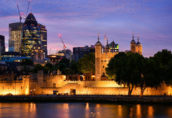 Fototapeta na wymiar Sunset view of the Tower of London, a famous castle and a former prison on the Tower Hill in the center of London, United Kingdom, from the Tower Bridge