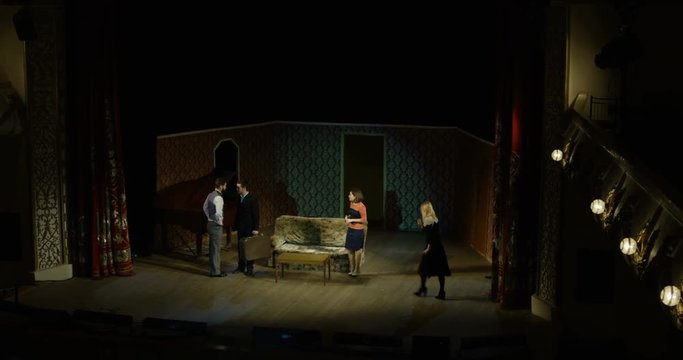 Full shot of actors performing a dramatic scene in a theater