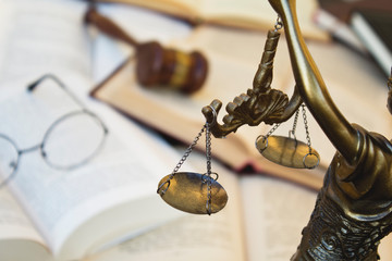 Statue of justice, judge gavel and open books.