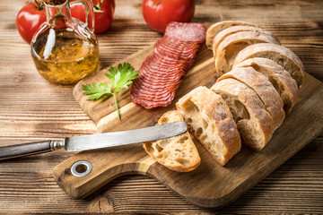 Italian ciabatta bread cut in slices with salami.