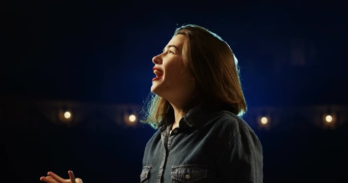 Medium close-up of an actress rehearsing a monologue in a theater while holding her script