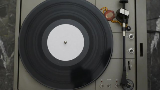 A fan of high-fidelity music starts the record player for listening to a vinyl. Automatic return of the arm