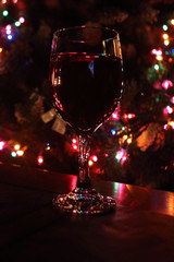 Celebration holiday wine with colorful bokeh lights and reflections on glass