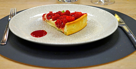 Slice of lemon and fresh raspberry tart on a plate