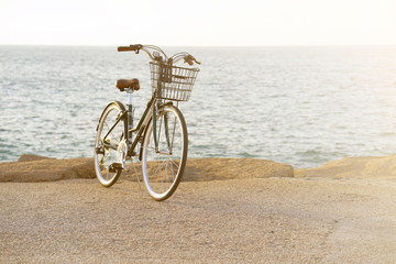 Obraz premium Bicycle parked on beach. Retro bike near the sea. Bike on the background of the sea horizon. Toning