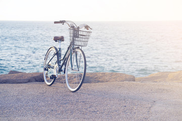 Fototapeta premium Bicycle parked on beach. Retro bike near the sea. Bike on the background of the sea horizon. Toning