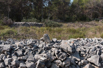 Stack of sharp grey stones in nature. Part of drywall.