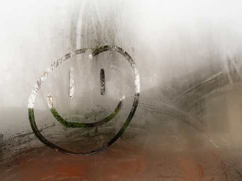 Cartoon Happy Smiley Face Drawn On A Condensation Covered Window During The Day Time