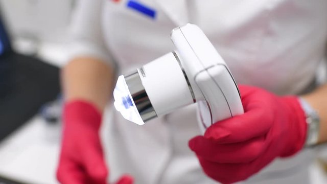 doctor dermatologist diagnoses hair structure using a special tool-a trichoscope. Trichology, trichogram