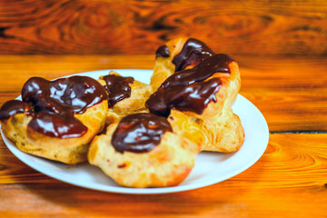 chocolate eclairs on a wooden background