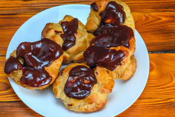 chocolate eclairs on a wooden background