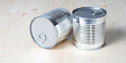 Tin cans for food on white wooden table