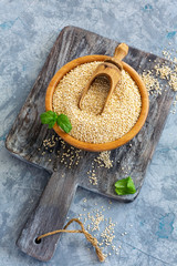 Raw organic quinoa seeds in a wooden bowl.