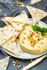Traditional hummus with pine nuts and pita bread.
